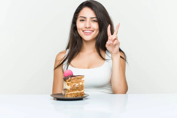 Genç Spanyol Kadın Iki Numarayı Parmaklarıyla Gösteren Bir Pasta Yiyor — Stok fotoğraf