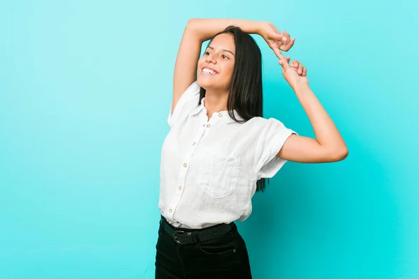 Ung Latinamerikansk Cool Kvinna Mot Blå Vägg Sträcker Armar Avslappnad — Stockfoto