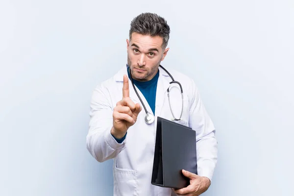 Καυκάσιος Γιατρός Κρατά Ένα Φάκελο Που Δείχνει Νούμερο Ένα Δάχτυλο — Φωτογραφία Αρχείου