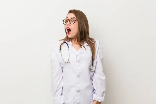 Jonge Dokter Vrouw Tegen Een Witte Muur Wordt Geschokt Door — Stockfoto