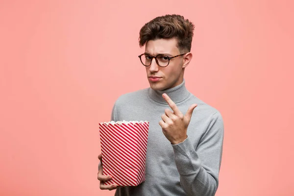 Young Intellectual Man Holding Popcorn Bucket Impressed Holding Copy Space — Stock Photo, Image