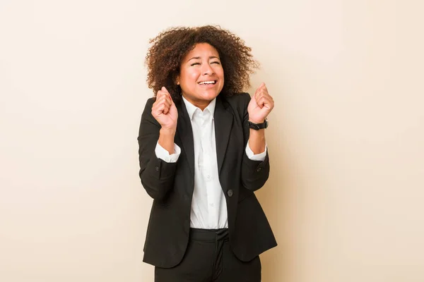 Young business african american woman raising fist, feeling happy and successful. Victory concept.
