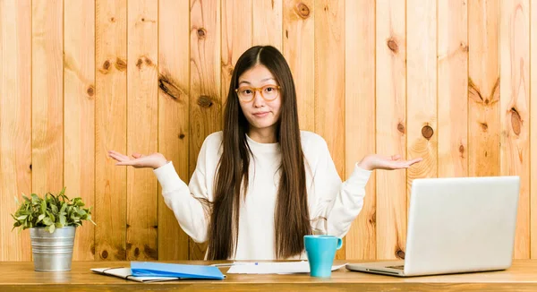 Jovem Chinesa Estudando Sua Mesa Duvidar Ombros Encolhendo Gesto Questionamento — Fotografia de Stock