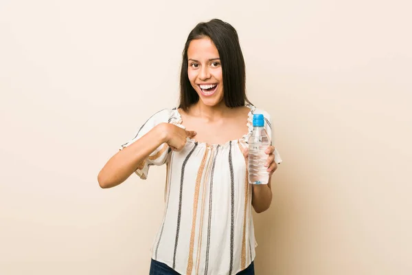 Junge Hispanische Frau Mit Einer Flasche Wasser Überrascht Zeigt Auf — Stockfoto
