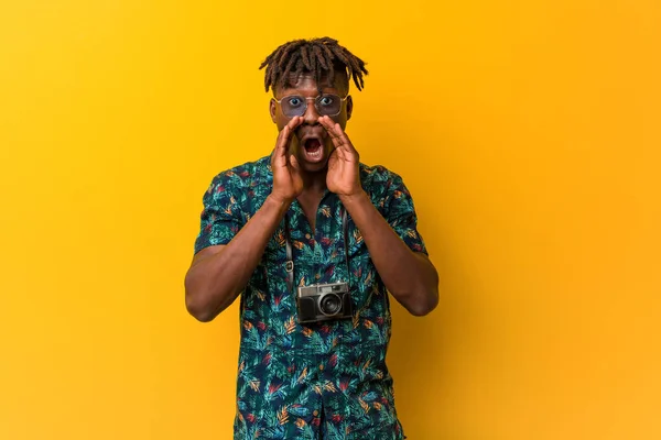 Young black rasta man wearing a vacation look shouting excited to front.