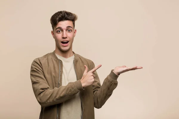 Young Caucasian Man Wearing Brown Jacket Excited Holding Copy Space — Stockfoto