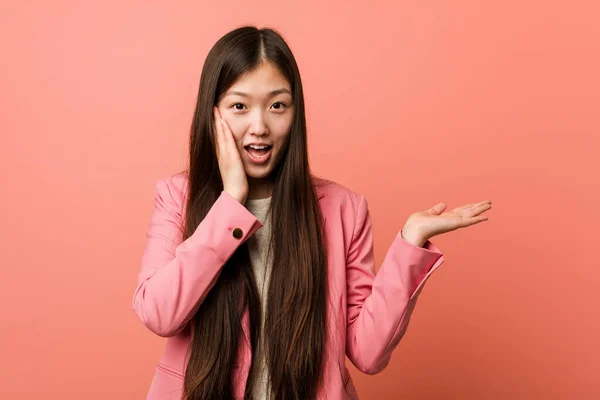 Young Business Chinese Woman Wearing Pink Suit Holds Copy Space — Stockfoto