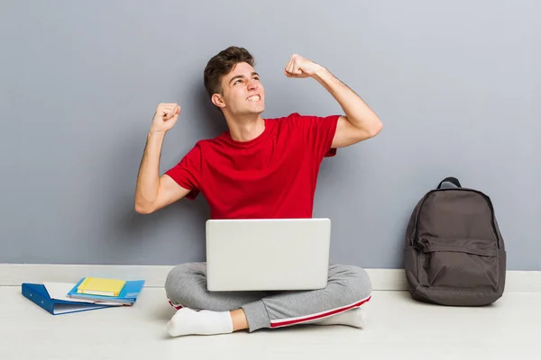 Young student man sitting on his house floor holding a laptop — Stock Photo, Image