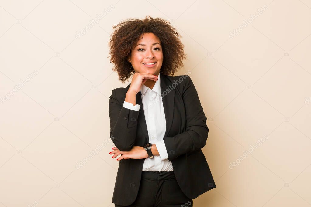 Young business african american woman smiling happy and confident, touching chin with hand.