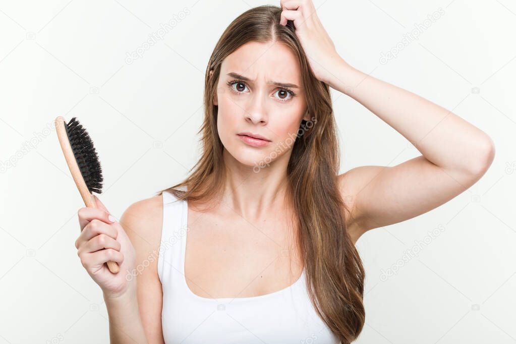 Young caucasian woman holding a hair brush being shocked, she has remembered important meeting.