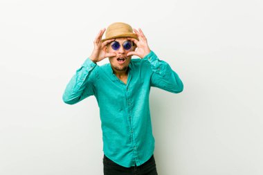 Yaz kıyafetleri giyen genç İspanyol bir adam başarılı bir fırsat yakalamak için gözlerini açık tutuyor..