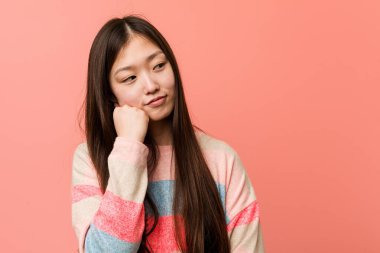 Üzgün ve dalgın hisseden genç, havalı Çinli kadın, kopyalama alanına bakıyor..