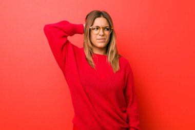 Genç otantik karizmatik gerçek insanlar kadın bir duvara karşı başının arkasına dokunarak, düşünme ve bir seçim yapma.