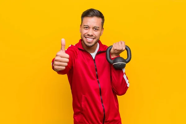 Young south-asian sport man holding a dumbbell