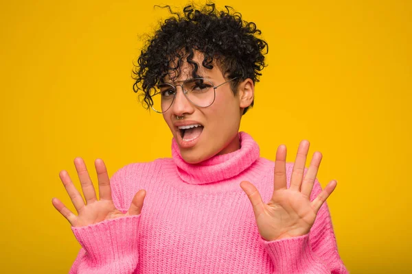 若いアフリカ系アメリカ人の女性ピンクのセーターを着て嫌悪感のジェスチャーを示す誰かを拒否 — ストック写真