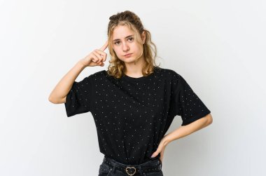 Beyaz arka planda beyaz tenli genç bir kadın parmağıyla tapınağı işaret ediyor, düşünüyor ve bir göreve odaklanıyor..