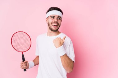 Badminton oynayan beyaz bir genç parmak uzakta, gülerek ve kaygısızca noktalar çiziyor..