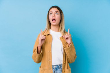 Kafkasyalı genç bir kadın ağzı açık bir şekilde üst tarafı işaret ediyor..