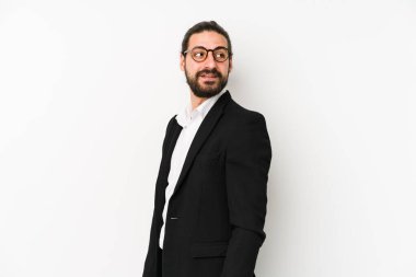Beyaz bir arka planda izole edilmiş beyaz iş adamı gülümseyen, neşeli ve keyifli bir tarafa bakıyor..