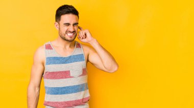 Kafkasyalı genç adam sarı fırında izole edilmiş kulakları elleriyle kapatıyor..