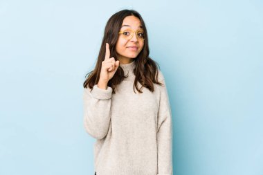 Genç, melez, Latin bir kadın bir numarayı parmağıyla gösteriyor..