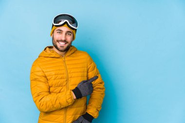 Genç kayakçı Kafkasyalı izole edilmiş gülümseyen ve işaret eden boş alanda bir şey gösteriyor..