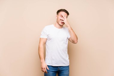 Kafkasyalı genç adam kameraya parmaklarıyla göz kırpıyor, yüzünü kapatmaktan utanıyor..