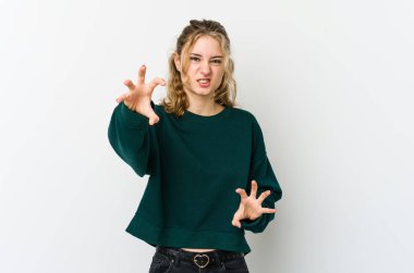 Beyaz arka plandaki genç beyaz kadın pençelerini kedi taklidi yaparken gösteriyor, agresif bir hareket..