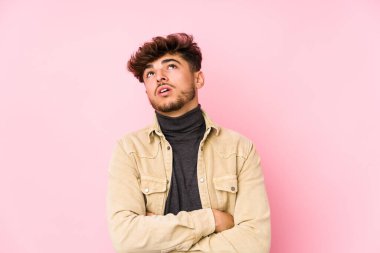 Arka planda poz veren genç Arap adam tekrarlanan bir görevden yoruldu..