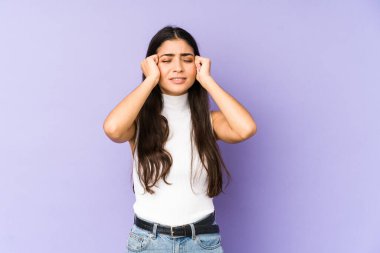 Mor arka planda izole edilmiş genç Hintli bir kadın ağlıyor, bir şeyden memnun değil, acı ve kafa karışıklığı konsepti..