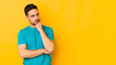 Kafkasyalı genç adam sarı fırında izole edilmiş şüpheli ve şüpheci bir ifadeyle yana bakıyor..