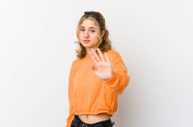 Beyaz arka plandaki genç beyaz kadın iğrenme hareketi gösteren birini reddediyor..