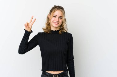 Beyaz sırtlı beyaz kadın neşeli ve kaygısız parmaklarıyla barış sembolü gösteriyor..