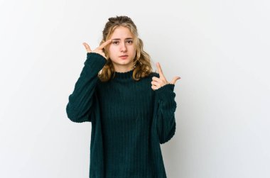 Beyaz arka plandaki genç beyaz kadın işaret parmağıyla hayal kırıklığı jesti yapıyor..