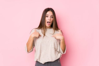 Kafkasyalı bir kadın yalnız poz veriyor. Parmakla işaret ediyor, gülümsüyor..