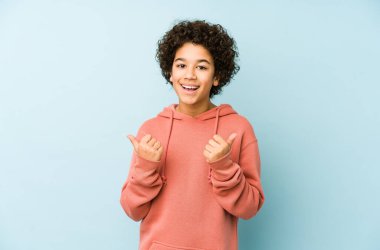 Afro-Amerikalı küçük çocuk kendini soyutlamış iki parmağını da kaldırıyor, gülümsüyor ve kendinden emin..