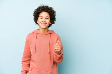 Afrikalı Amerikalı küçük çocuk kendini izole etmiş gülümsüyor ve başparmağını kaldırıyor.