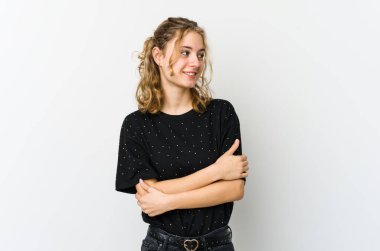 Beyaz sırtında genç beyaz bir kadın. Kollarını kavuşturup gülümsüyor..