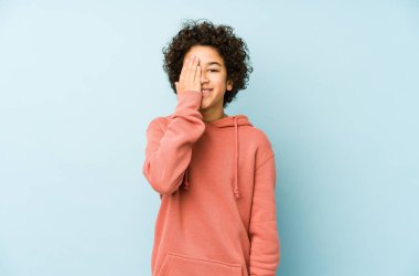 Afrika kökenli Amerikalı küçük bir çocuk izole edilmiş, yüzünün yarısını avuç içiyle kaplayarak eğleniyor..