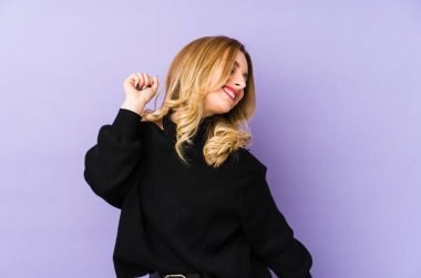 Genç sarışın kadın dans ediyor ve eğleniyor..