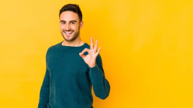 Kafkasyalı genç adam sarı fırında izole edilmiş neşeli ve kendinden emin..