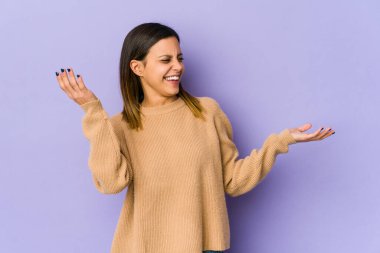 Mor arka planda izole edilmiş genç bir kadın neşeli bir şekilde gülüyor. Mutluluk kavramı.