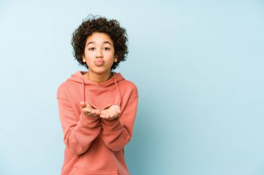 Afrika kökenli Amerikalı küçük çocuk, dudaklarını katlayıp avuç içlerine hava öpücüğü yolluyor..