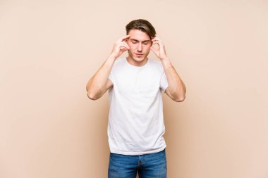 Kafkasyalı genç adam soyutlanmış poz veriyor tapınaklara dokunuyor ve baş ağrısı çekiyor..