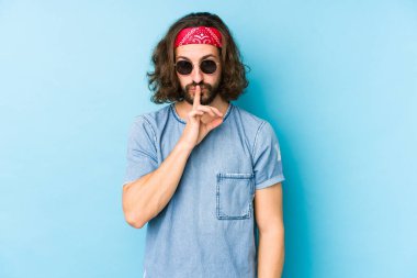 Genç, uzun saçlı, festival hippisi gibi giyinmiş bir adam. Sır saklıyor ya da sessizlik istiyor..