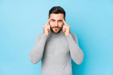 Mavi bir geçmişi olan genç beyaz bir adam bir göreve odaklanmış ve işaret parmaklarını işaret ediyor..