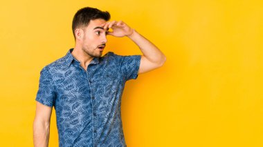 Kafkasyalı genç adam sarı fırında izole edilmiş uzaklara bakıyor ve elini alnına koyuyor..