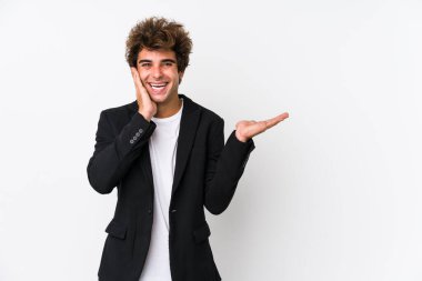 Beyaz arka planı olan beyaz tenli genç bir iş adamı bir avuç içinde fotokopi alanı tutuyor, el üstünde tutuyor. Şaşırmış ve mutlu..