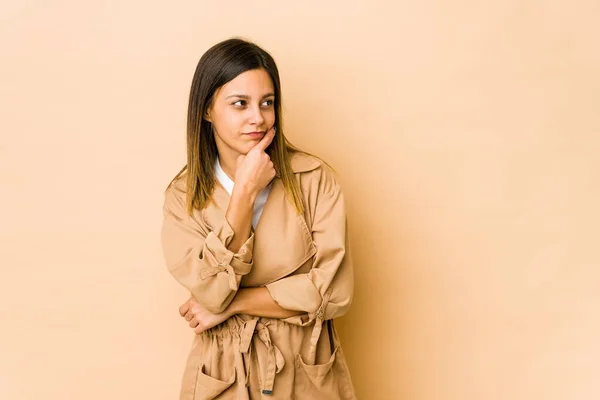 Mujer Joven Aislada Sobre Fondo Beige Contemplando Planificando Una Estrategia —  Fotos de Stock