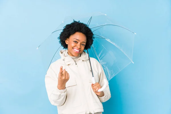 若いですアフリカ系アメリカ人女性保持しています傘隔離されたポインティングとしてあなたに指で近くに来る — ストック写真